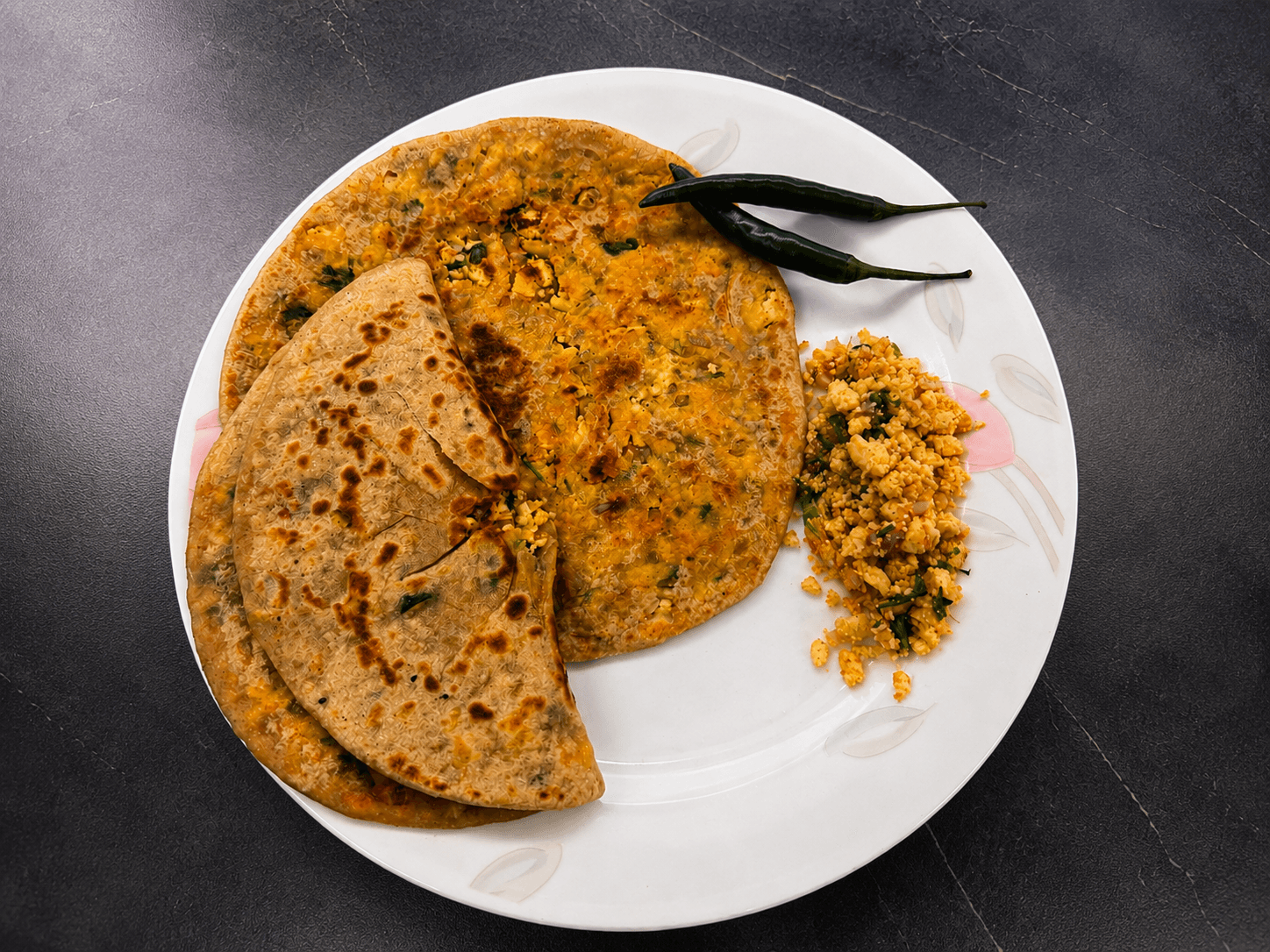 A stuffed paneer paratha, hot off the tawa and topped with white butter.